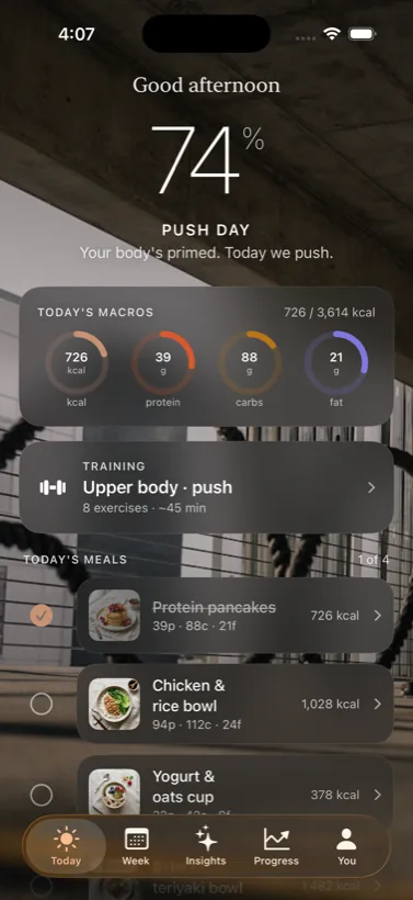 The Basis Today screen: a 74% recovery readout, today’s macros, and the day’s meals over a warm gym scene.